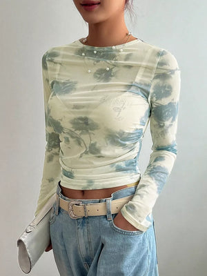 Sheer floral print long sleeve t-shirt with crew neck and ruched sides.