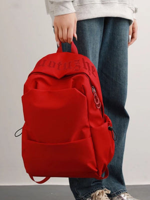 Red nylon drawstring backpack with padded straps and embroidered text detail.