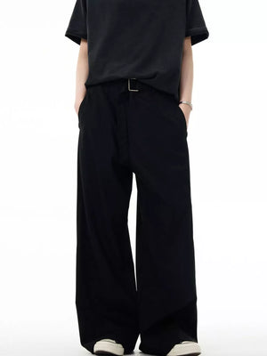 Men's black wide-leg sweatpants with a silver buckle detail and pockets.