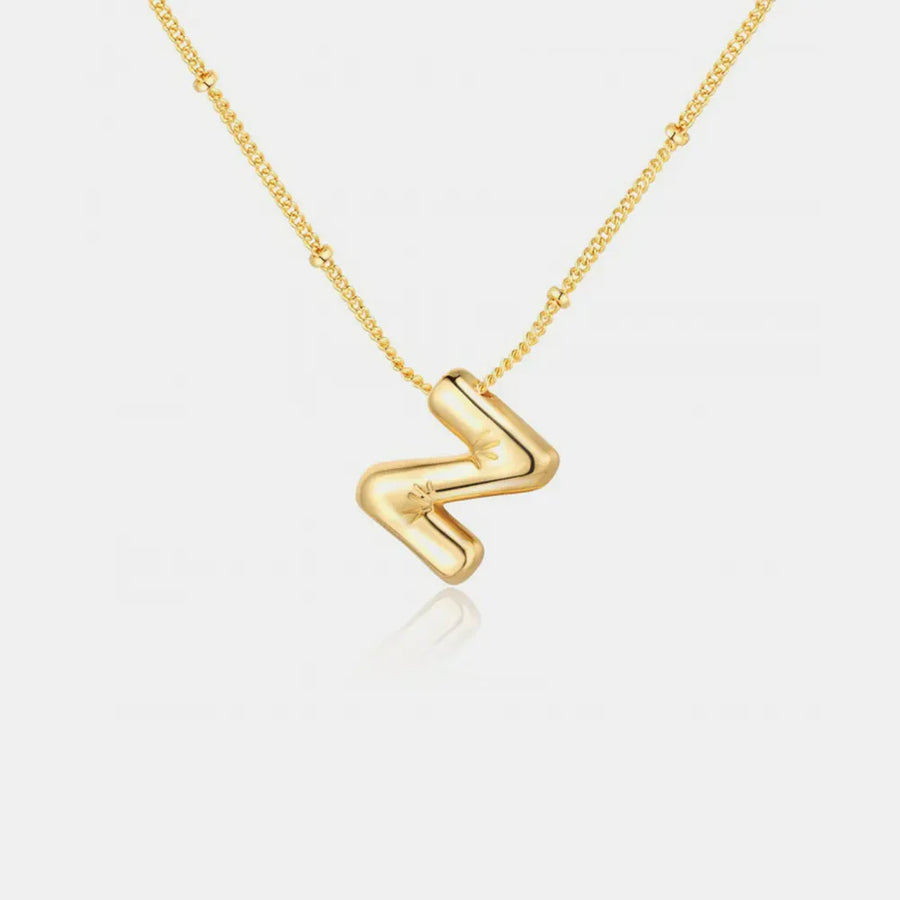 Gold initial pendant necklace with a bubbly letter Z charm and star detail.