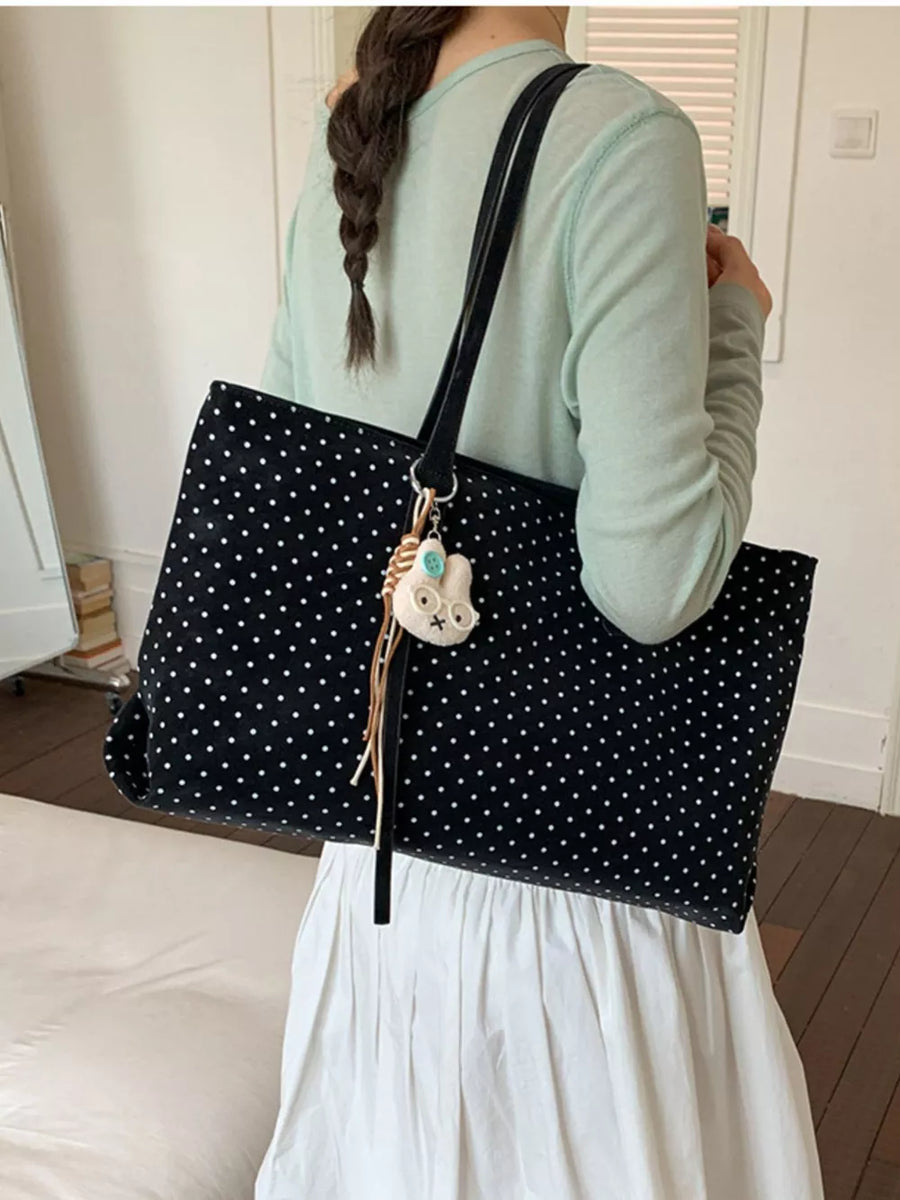 white handbag featuring shoulder straps and polka dot