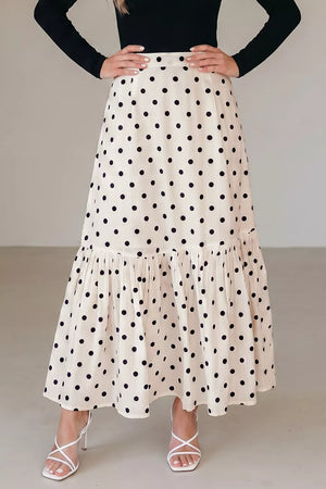 Chic polka dot maxi skirt in beige with a ruffled hem and subtle vertical stripes.