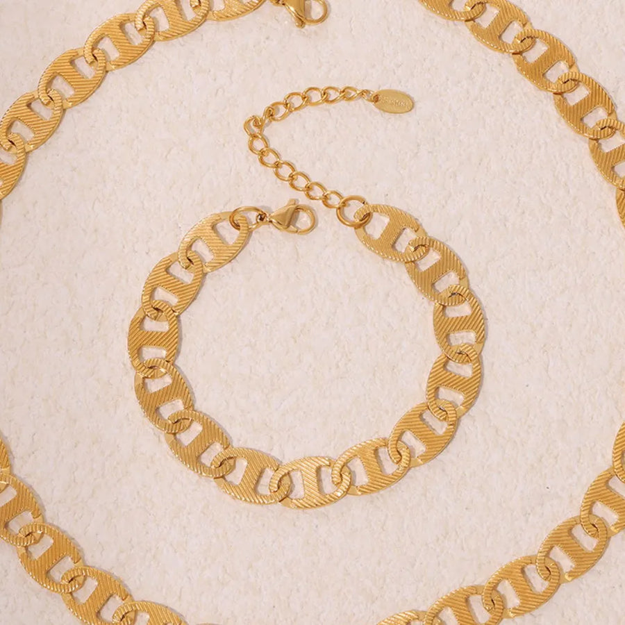Textured gold oval link bracelet with adjustable chain and lobster clasp.
