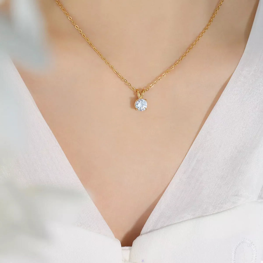 Gold zircon pendant necklace with delicate chain, showcasing a single sparkling stone.