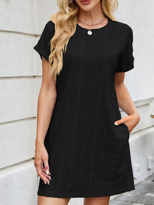 Black eyelet mini dress with crew neck, short sleeves, and pockets.