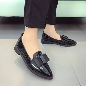 Black patent leather loafers with bow detail