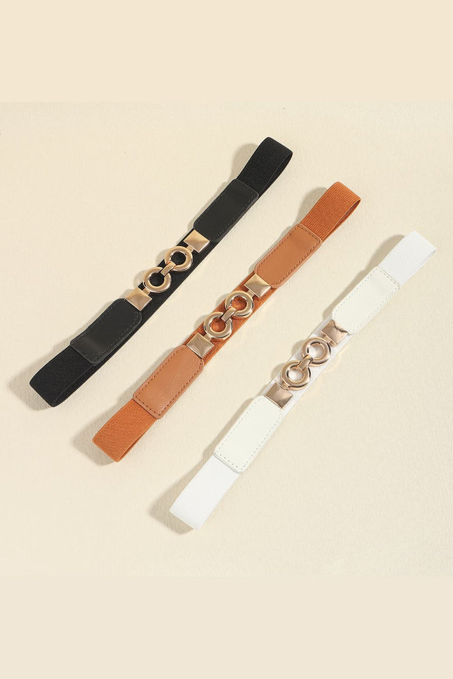Elastic waist belt in black, caramel, and white with gold interlocking ring detail
