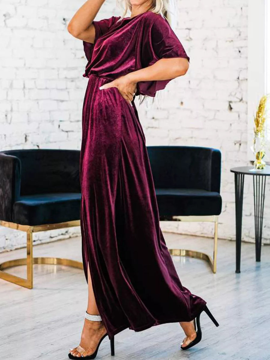 Burgundy velvet maxi dress with flutter sleeves, cinched waist, and high slit.