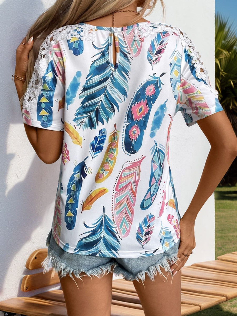 White feather print blouse with crochet sleeves and a keyhole back detail.