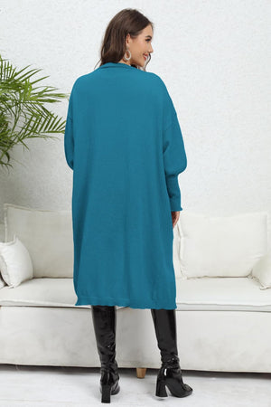 Cerulean oversized knit cardigan with pockets and long sleeves, shown from the back.