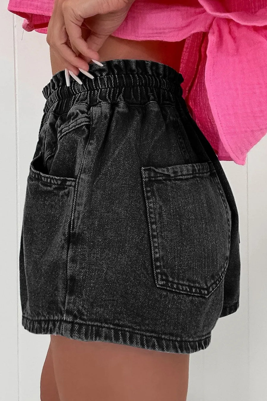 Black denim paperbag waist shorts with relaxed fit and back pockets.