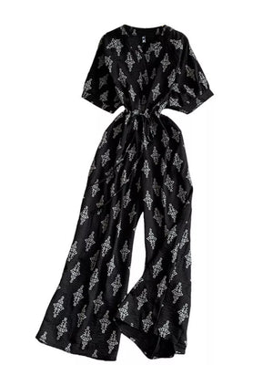 Black patterned jumpsuit with drawstring waist and wide legs.