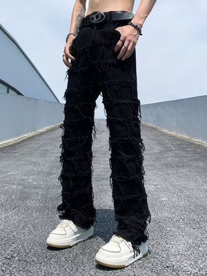 Black distressed slim fit jeans with frayed detailing and rips.