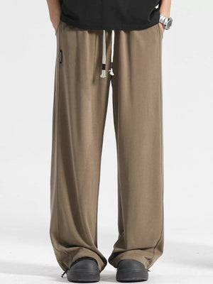 Men's light brown loose fit sweatpants with drawstring waist and cuffed ankles.