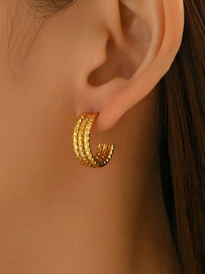 Gold earrings featuring textured and geometric