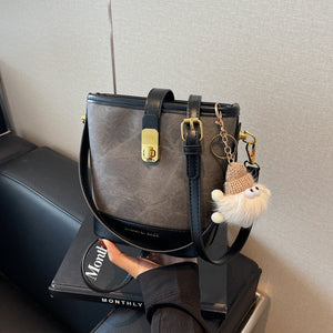 Vintage bucket crossbody bag in black with gold hardware and cute charm