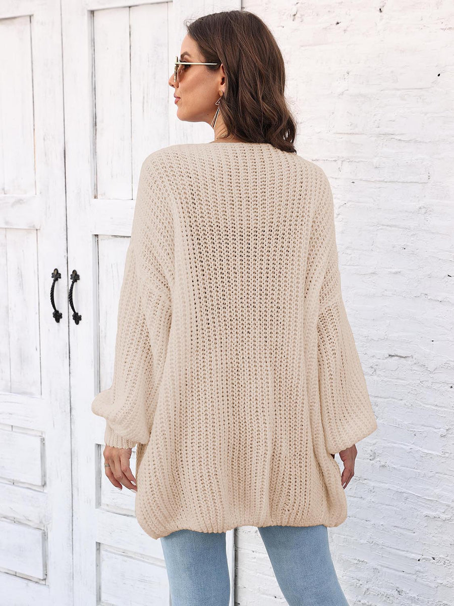 Beige open knit cardigan with balloon sleeves and ribbed texture.