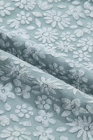 Light blue polyester shirt with white embroidered floral pattern and puff sleeve detail.