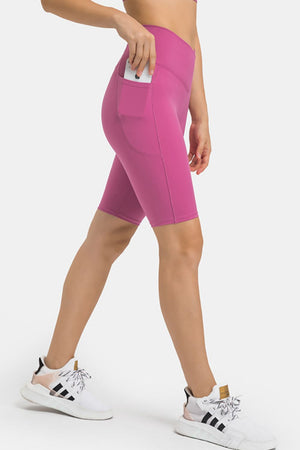 Hot Pink V-waist pocketed performance biker shorts with a phone in the pocket.