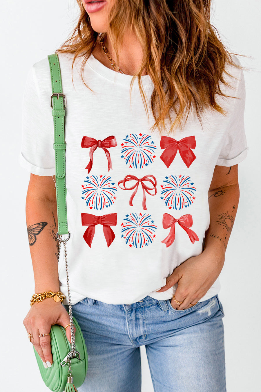 White t-shirt with red bows and red, white, and blue fireworks graphic pattern.
