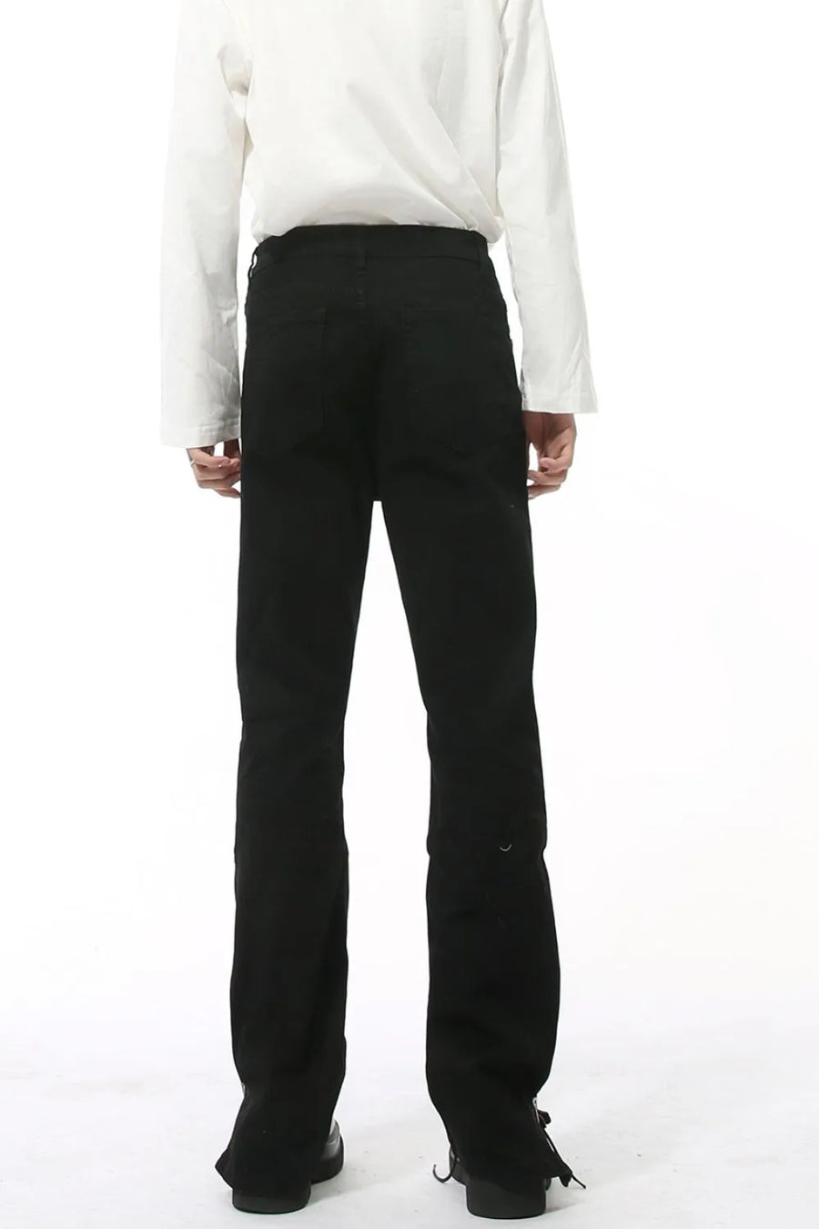 Split-hem black denim jeans with a tailored fit and subtle distressed detail.