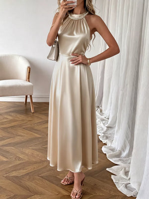 Champagne satin midi dress with pearl halter neckline and a-line skirt.