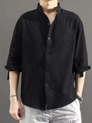 Black cotton button-down shirt with roll-up sleeves and chest pocket.