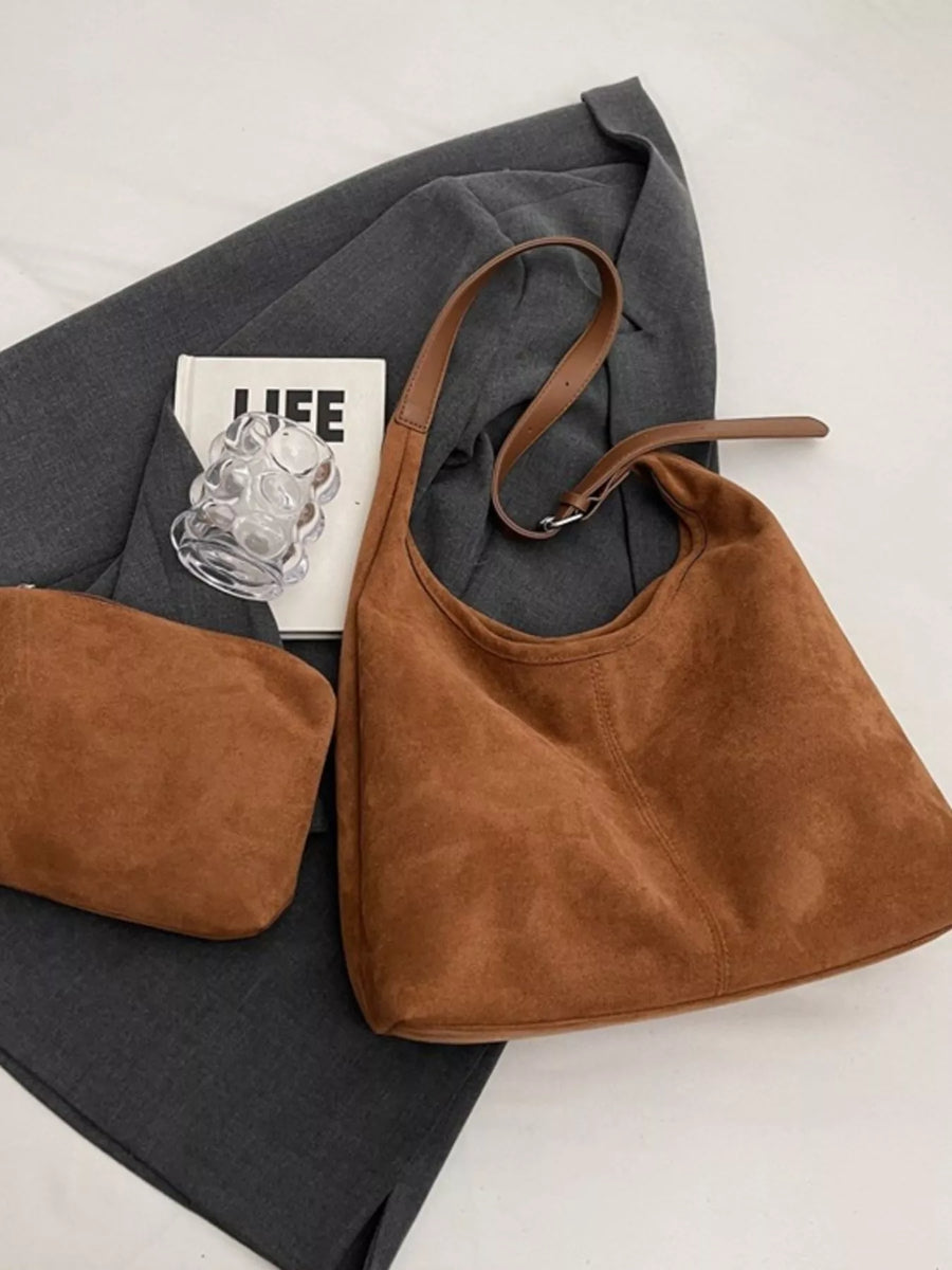 Brown suede hobo bag with adjustable strap and matching pouch.