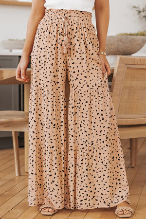 Dalmatian print palazzo trousers in watermelon pink with tiered ruffles and adjustable drawstring waist.