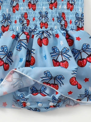 Baby bodysuit dress with cherry and bow print, smocked bodice, and snap closure.