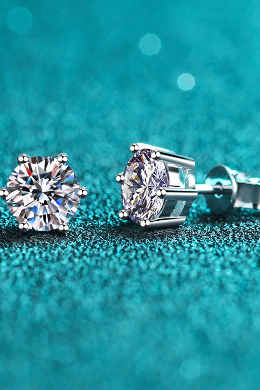 Silver six-prong moissanite stud earrings with brilliant cut stones.