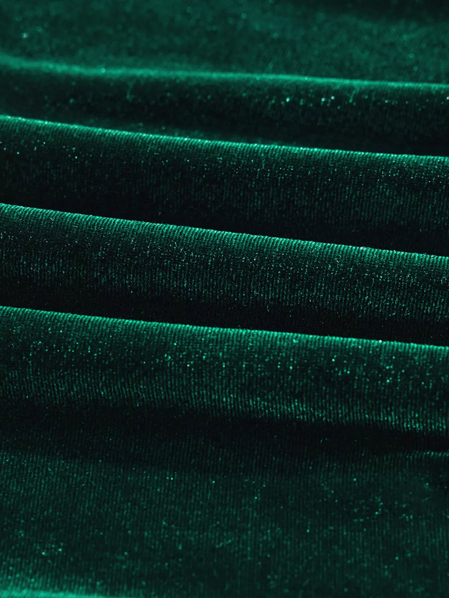Dark green velvet fabric with subtle sparkle detail, showing textured folds.