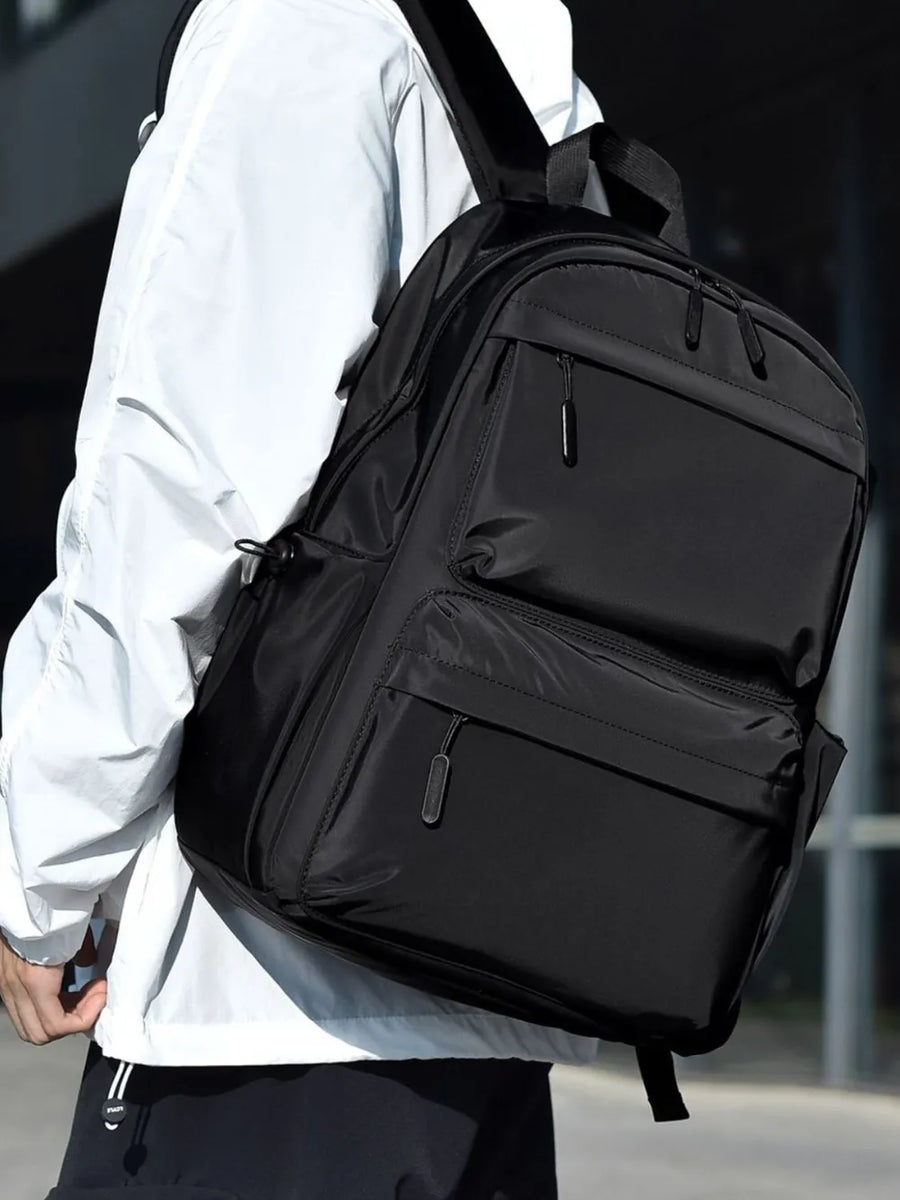 Black urban commuter backpack with multiple exterior zip pockets and side pouch.