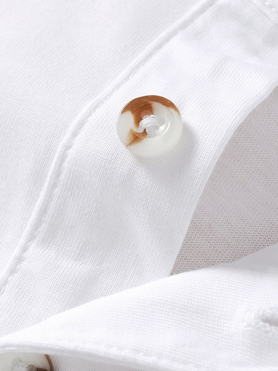 White cotton polo shirt with button detail and chest pocket.