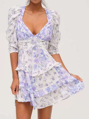 Ruched floral tie-front dress with ruffled tiers and puff sleeves in purple and white.