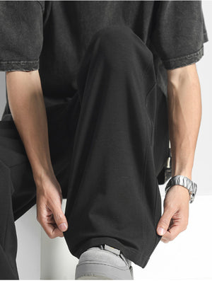Black men's casual loose-fit drawstring pants with a relaxed leg and elastic waistband detail.