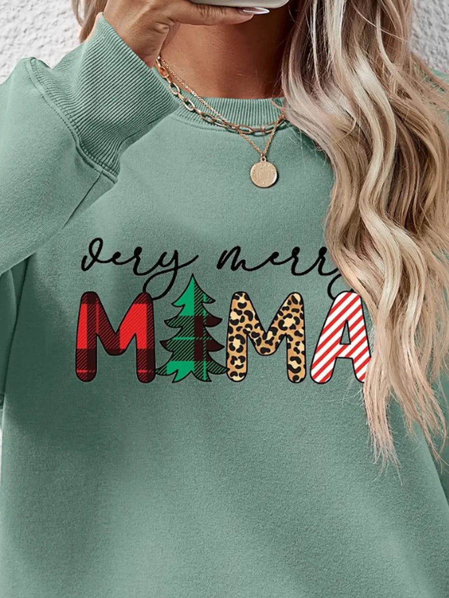 Sage green crewneck sweater with "Very Merry Mama" graphic featuring plaid, tree, leopard print, and stripes.