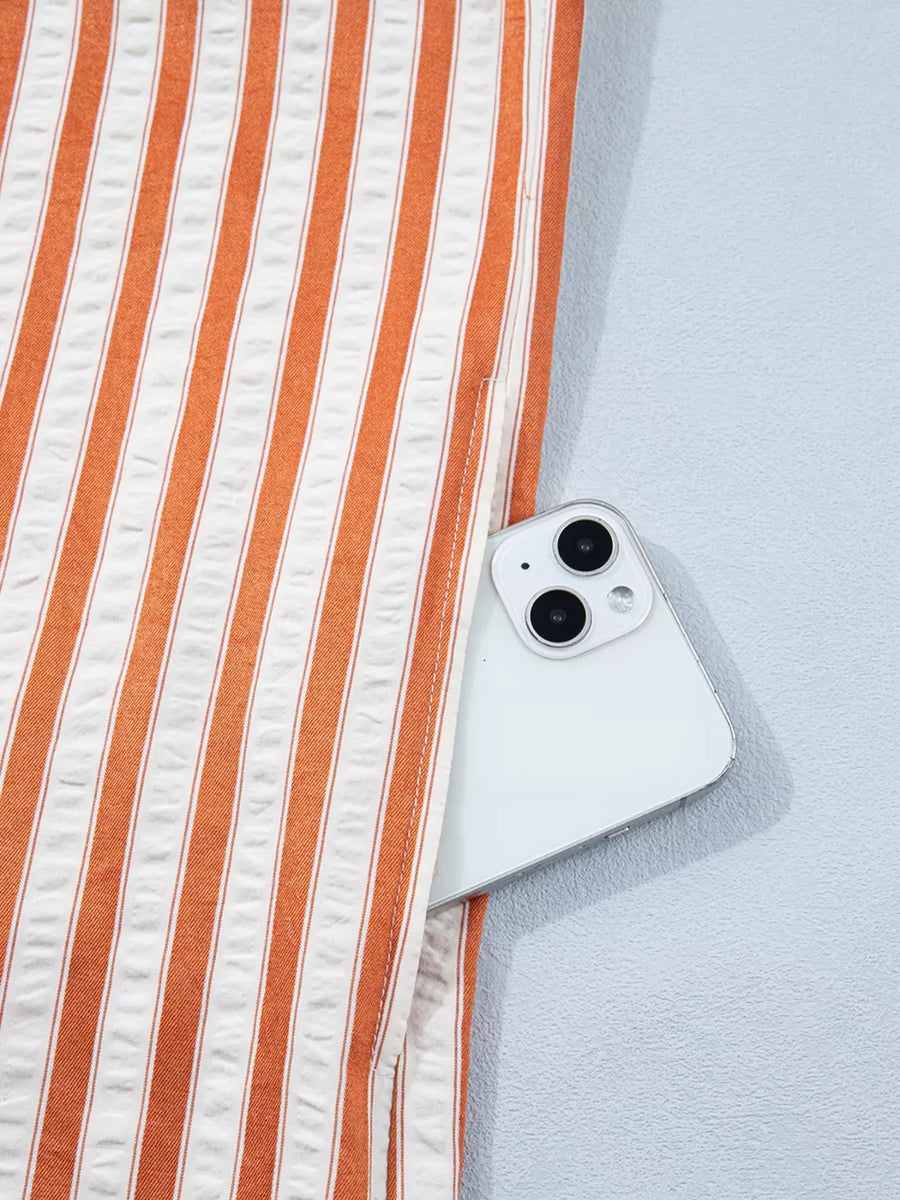 Orange and white striped shift mini dress with a pocket holding a smartphone.
