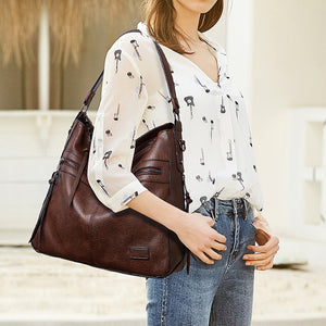 handbag in dark brown featuring zipper pockets and hobo fit