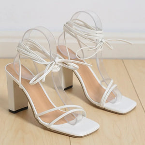 White lace-up square toe block heels with clear straps and ankle ties.