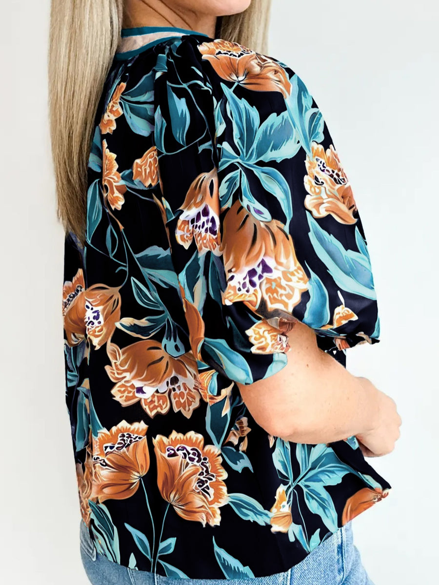 Black floral print bubble sleeve blouse with button detail.