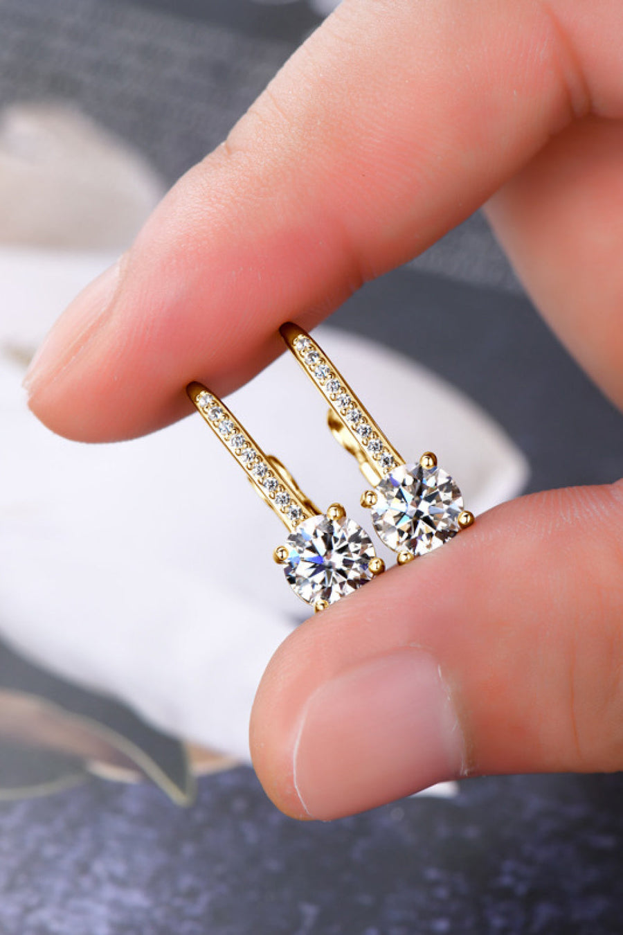 Gold leverback earrings with pavé-set moissanite and round-cut center stones.