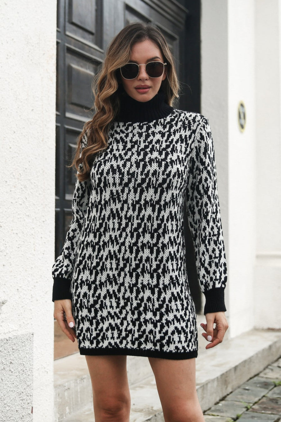 Black houndstooth knit turtleneck mini dress with long sleeves.