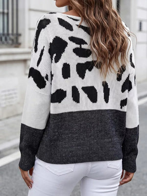 black pullover sweater featuring one-shoulder and cow-print