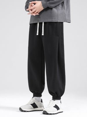 Black relaxed fit sweatpants with drawstring and cuffed ankles.