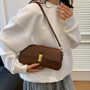 Brown rectangular crossbody bag with gold clasp and adjustable strap.
