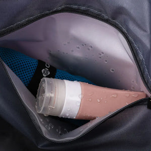 Expandable travel tote interior pocket with pink toiletry bottle and blue mesh item