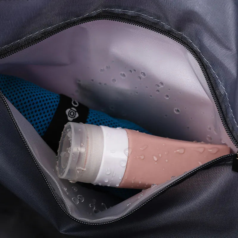 Expandable travel tote interior pocket with pink toiletry bottle and blue mesh item