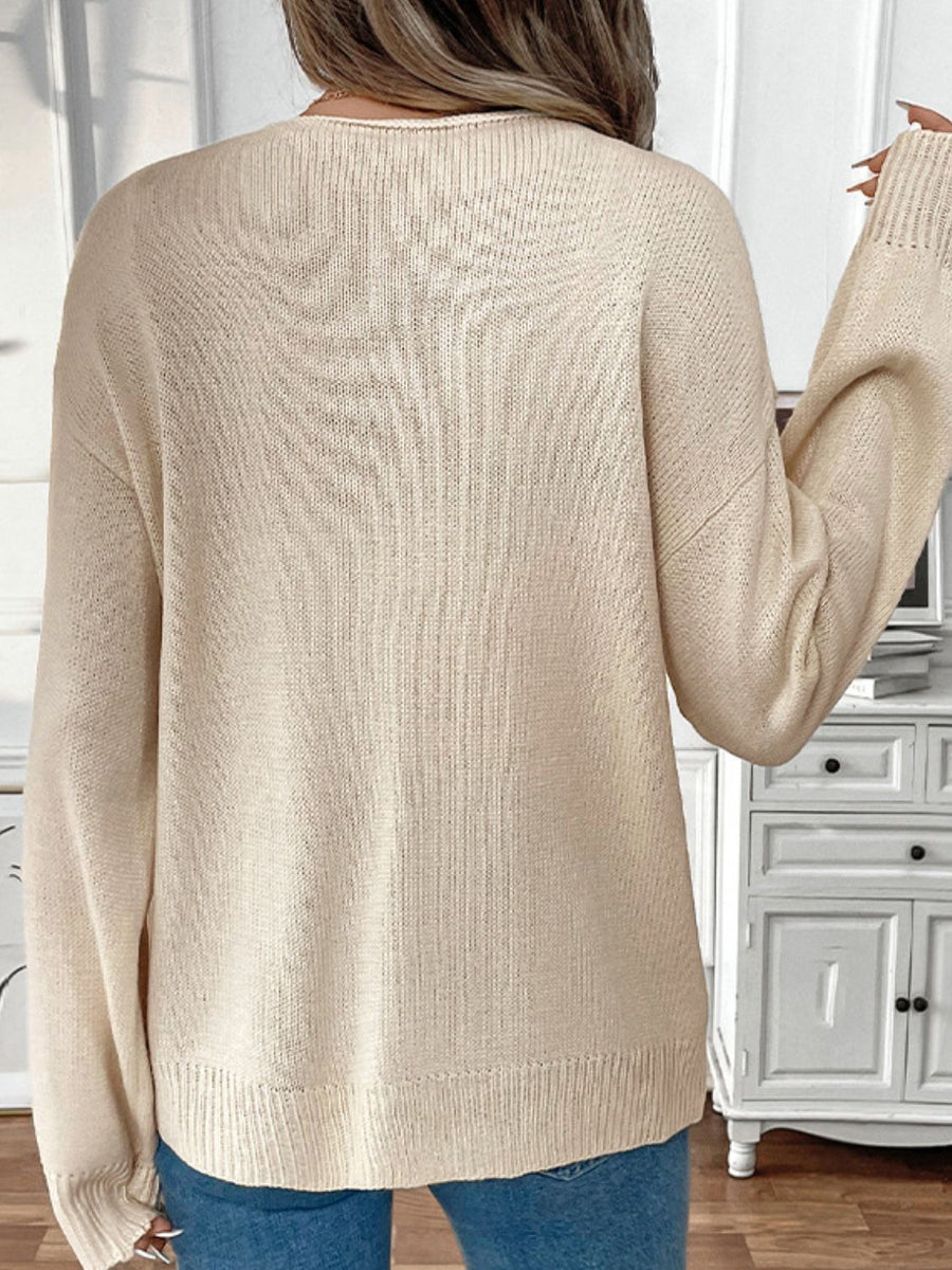 Cream acrylic knit cardigan with ribbed cuffs and hem, shown from the back.
