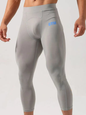 Gray compression capri pants with blue GYM logo detail